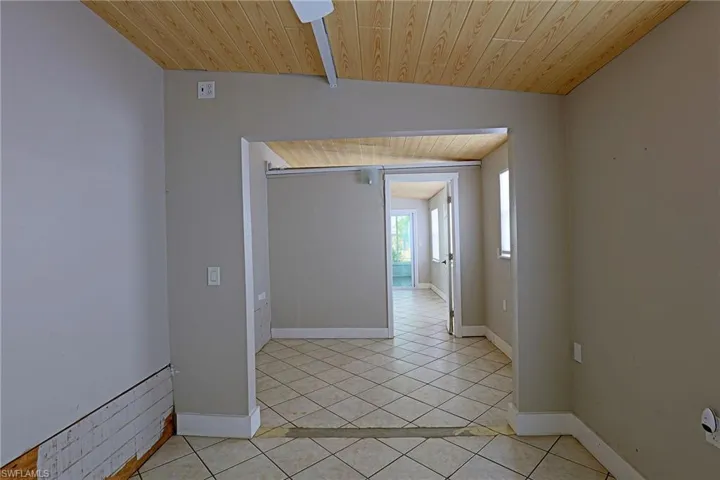 Spare room featuring wood ceiling, light tile patterned flooring, and lofted ceiling
