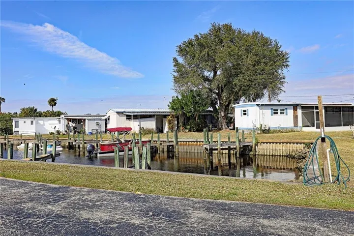 Dock area with boat lift, a yard, and a water view