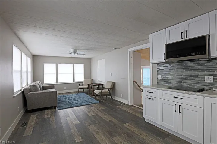Living room featuring dark wood-type flooring and ceiling fan
