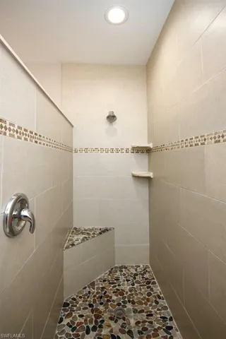 Full bath with tiled shower and recessed lighting