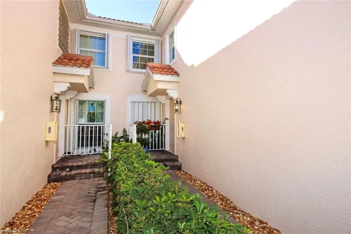 View of exterior entry featuring stucco siding and a tiled roof