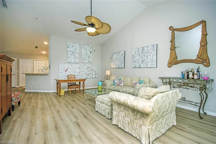 Living room featuring high vaulted ceiling, light wood-style flooring, a ceiling fan, and recessed lighting