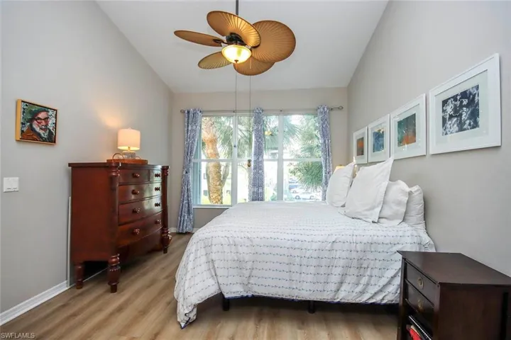 Bedroom featuring light wood-style floors, lofted ceiling, and ceiling fan