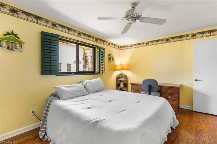 Bedroom featuring baseboards, ceiling fan, and wood finished floors