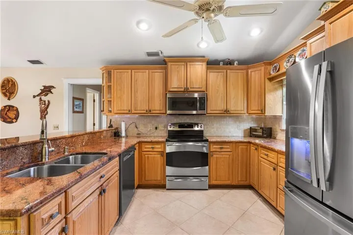 Kitchen with a sink, visible vents, backsplash, and appliances with stainless steel finishes