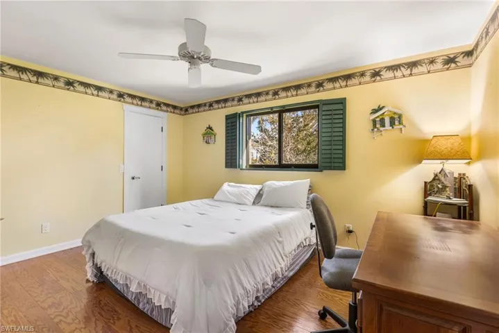 Bedroom with baseboards, wood finished floors, and a ceiling fan