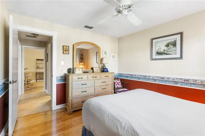 Bedroom featuring light wood-type flooring, a ceiling fan, and visible vents