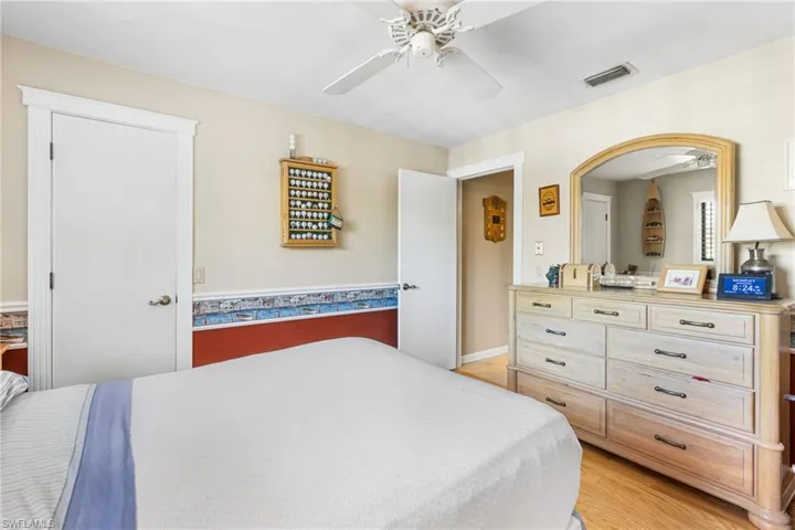 Bedroom with light wood-style flooring, visible vents, and ceiling fan