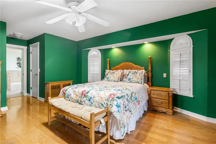 Bedroom featuring baseboards, wood finished floors, and a ceiling fan