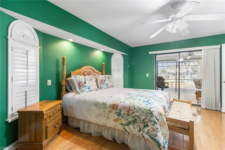 Bedroom with access to exterior, wood finished floors, and ceiling fan