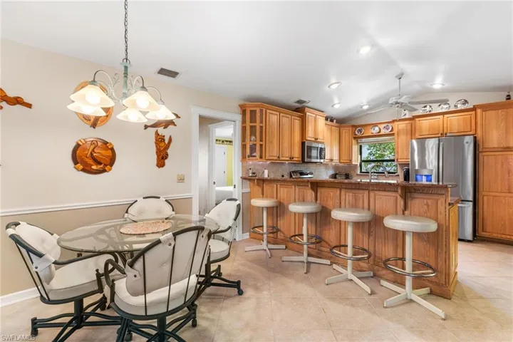 Kitchen with a kitchen breakfast bar, tasteful backsplash, lofted ceiling, stainless steel appliances, and visible vents