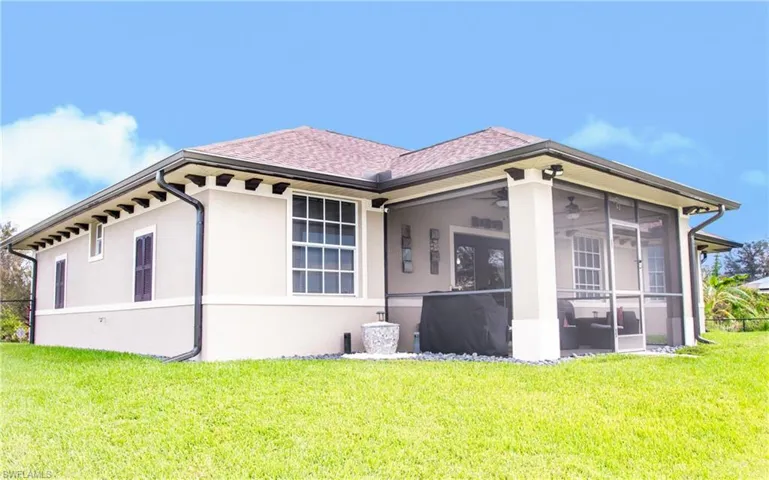 View of property exterior featuring a yard and a sunroom