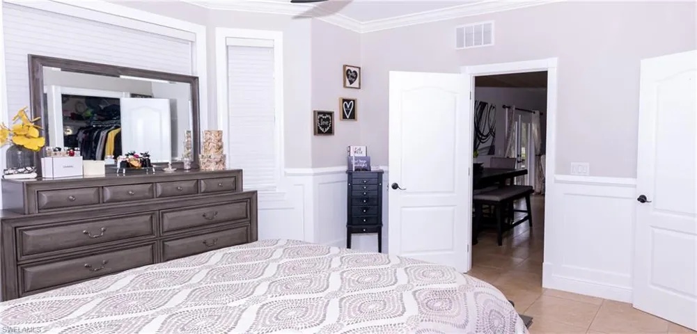 Tiled bedroom with a closet and crown molding
