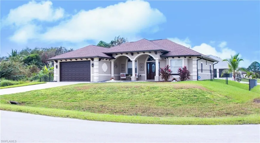 Mediterranean / spanish house with a garage and a front lawn
