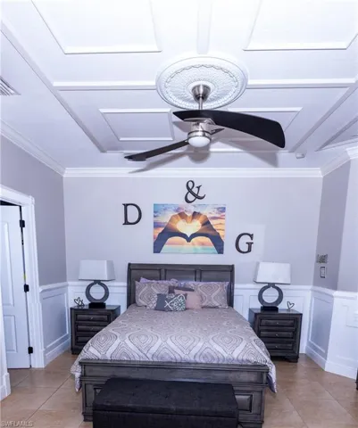Bedroom with crown molding, light tile patterned floors, and ceiling fan
