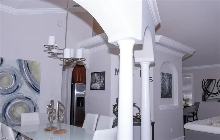 Dining space with crown molding and a notable chandelier