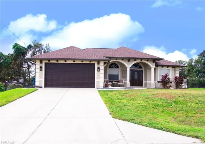 Mediterranean / spanish-style home with a front yard and a garage