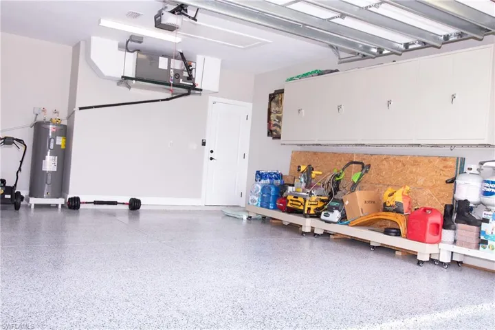Garage featuring a garage door opener and water heater