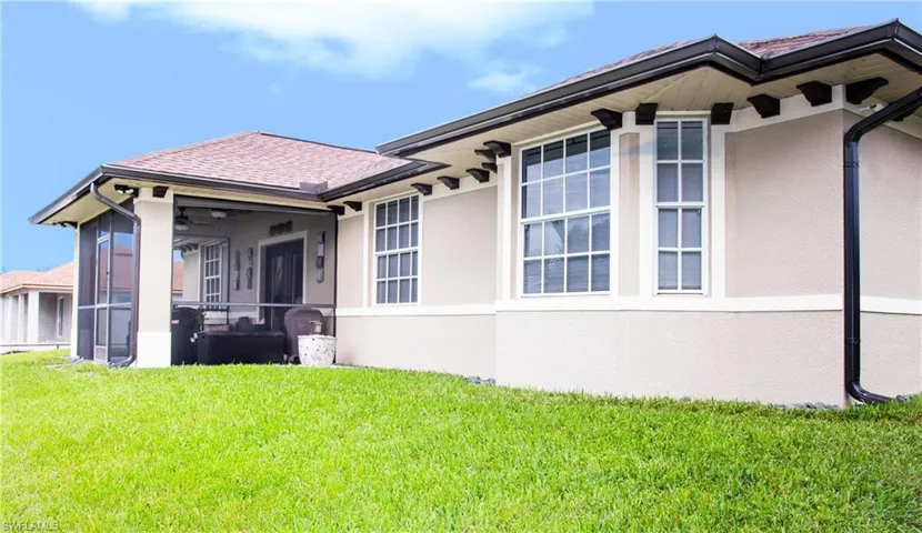 View of property exterior featuring a sunroom, a lawn, and ceiling fan
