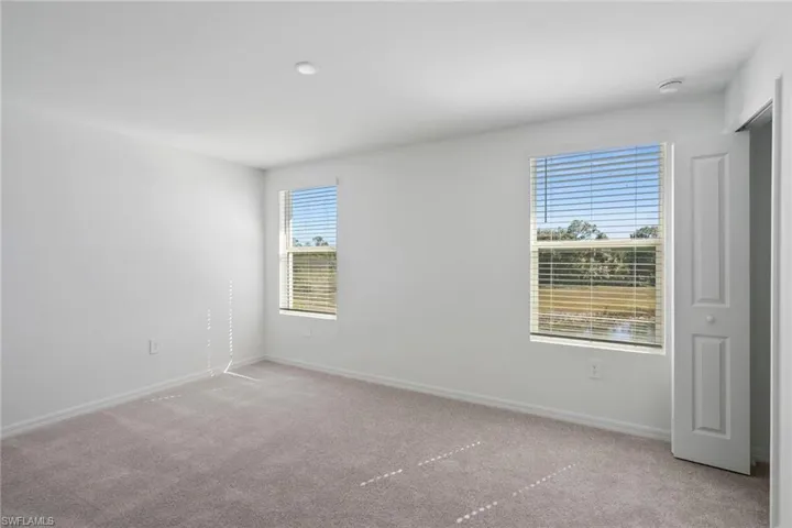 Empty room featuring light carpet and baseboards
