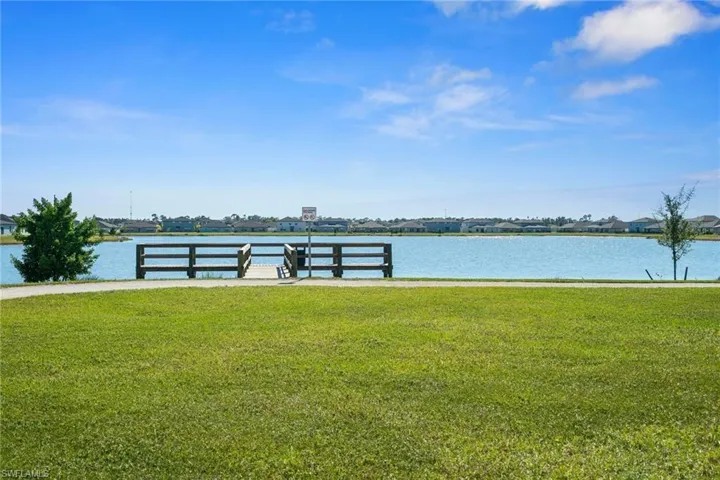 Dock area with a yard and a water view