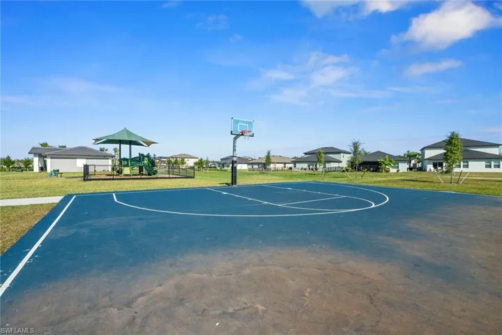 View of sport court with community basketball court, a lawn, and a residential view