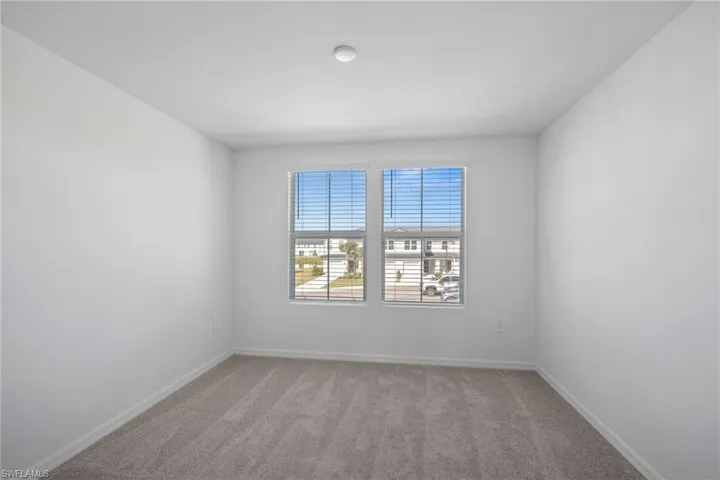 Spare room with light carpet and baseboards
