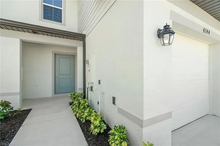 Doorway to property featuring stucco siding and a garage