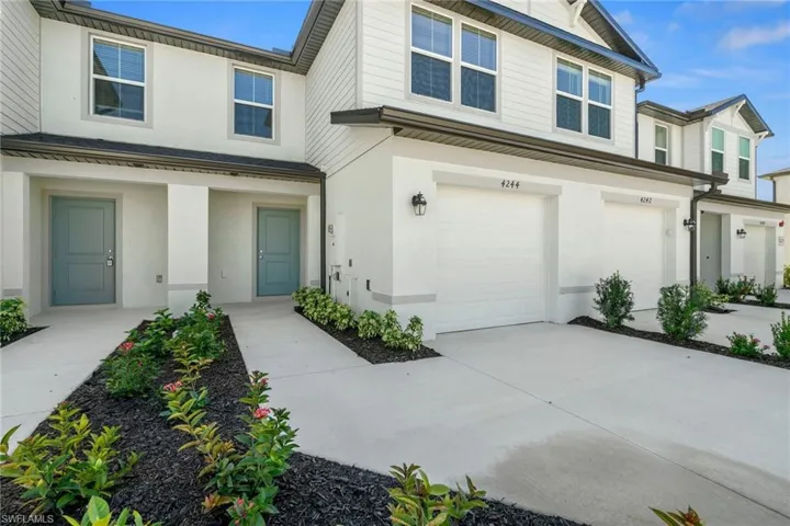 View of front of house with stucco siding, concrete driveway, and a garage