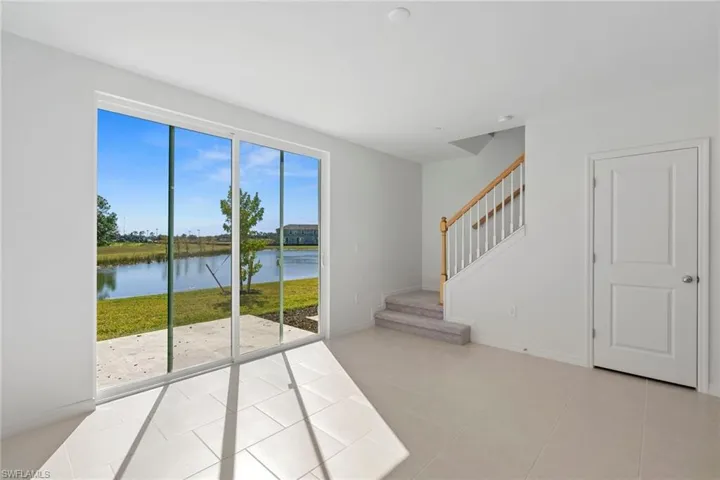 Entryway featuring a water view, stairway, and tile patterned floors