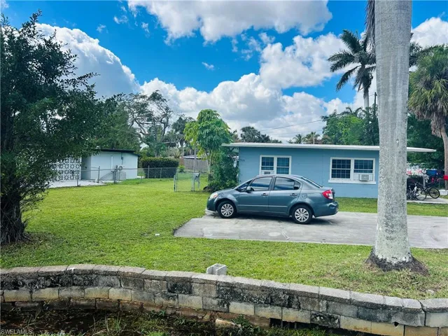 View of vehicle parking with driveway and fence