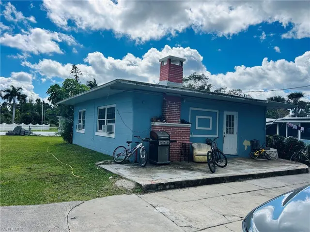 View of home's exterior with a yard, a chimney, a patio area, and cooling unit