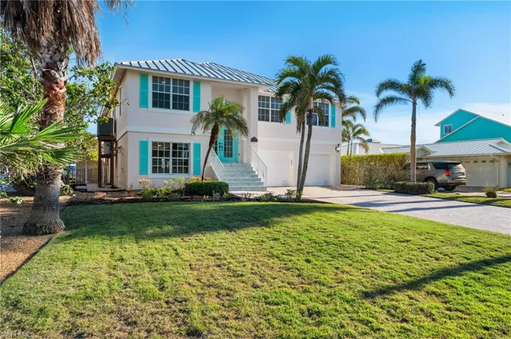 View of front of property featuring a carport, a garage, and a front lawn