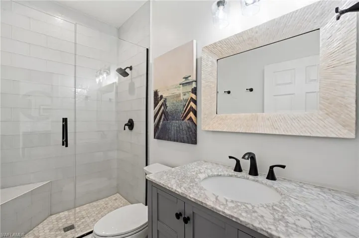 Bathroom featuring vanity, an enclosed shower, and toilet