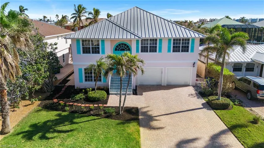 View of front of property featuring a garage and a front lawn