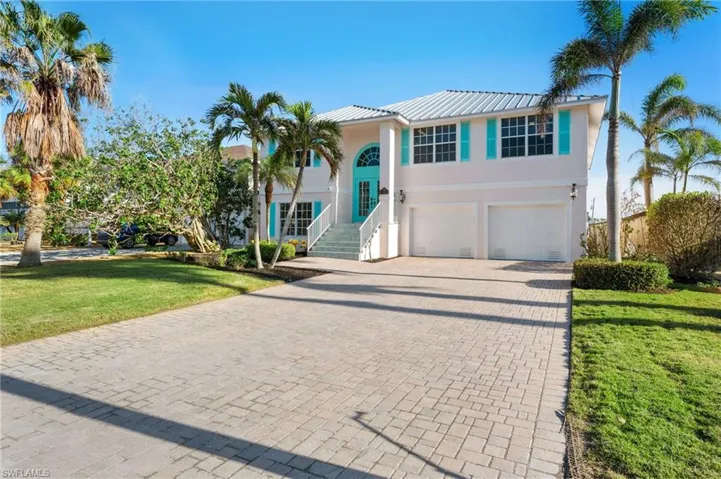 View of front of house with a garage and a front yard