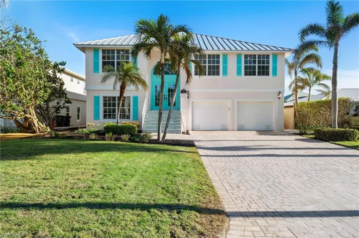 View of front facade featuring a garage and a front lawn