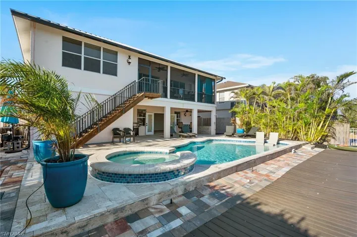 View of pool with a sunroom, a patio, ceiling fan, and an in ground hot tub