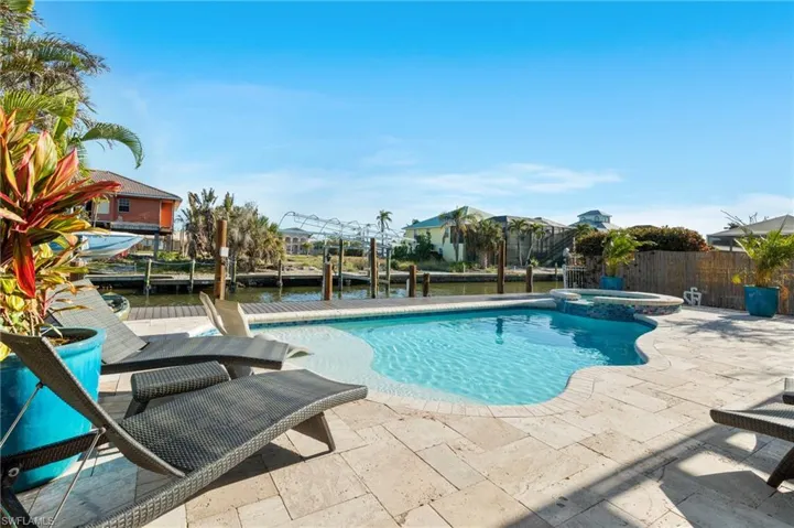 View of pool featuring an in ground hot tub, a water view, and a patio