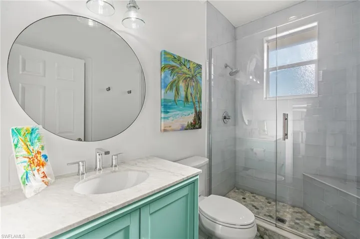 Bathroom featuring vanity, toilet, and walk in shower