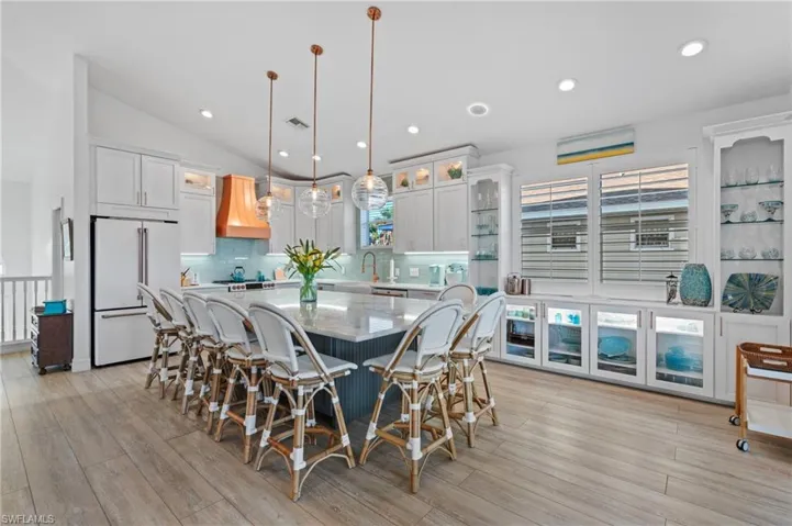 Dining room with lofted ceiling, sink, and light wood-type flooring