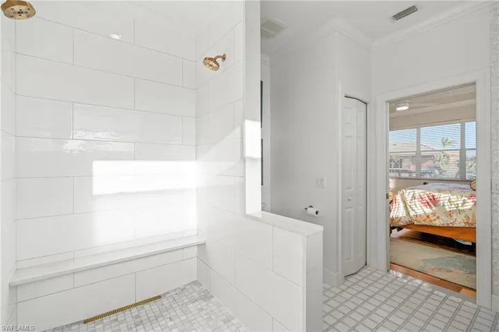 Bathroom with crown molding and walk in shower