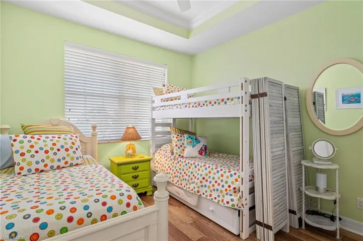Bedroom featuring crown molding, wood-type flooring, and ceiling fan
