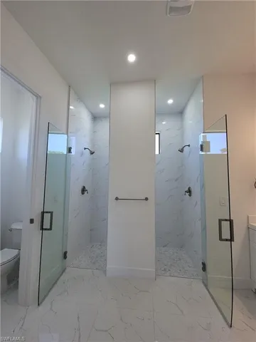 Bathroom with tile patterned floors, an enclosed shower, and toilet