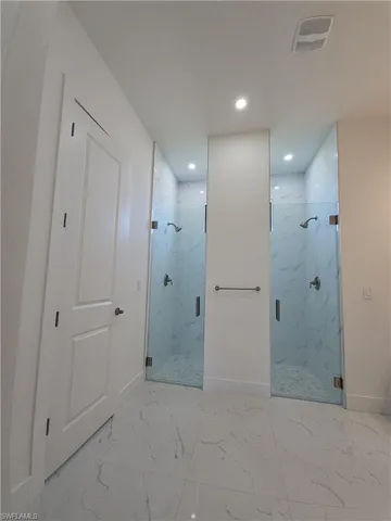 Bathroom featuring a shower with door and tile patterned flooring