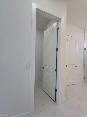 Hallway featuring light tile patterned flooring