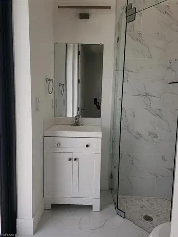 Bathroom with vanity, an enclosed shower, tile patterned flooring, and toilet
