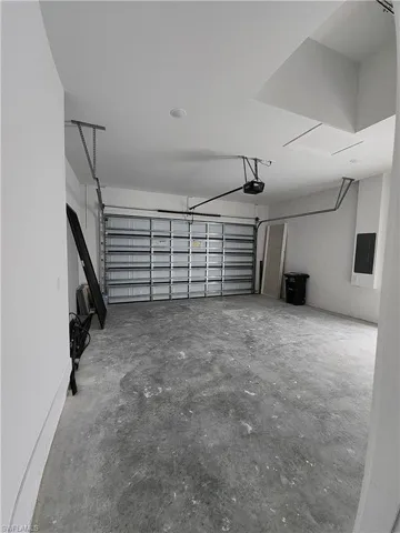 Garage featuring electric panel and a garage door opener