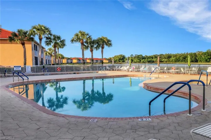 Community pool featuring a patio area and fence