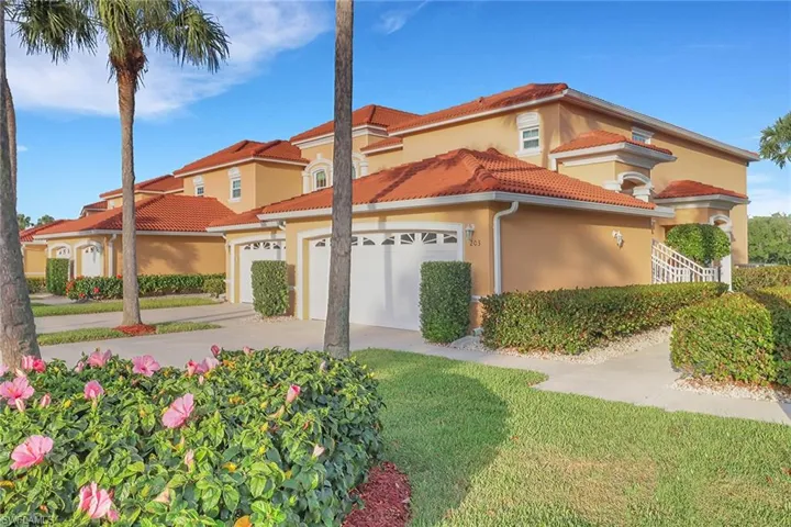 Mediterranean / spanish house with a tile roof, a front yard, driveway, stucco siding, and an attached garage